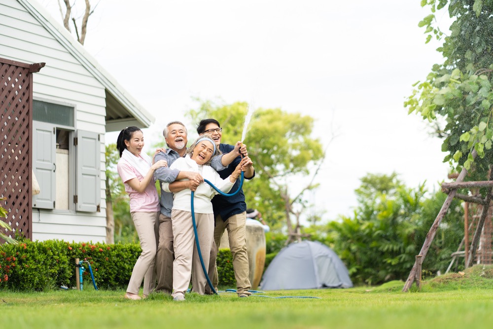 Asian,Family,Happy,Smiling,And,Watering,Green,Cultivated,Plants,With